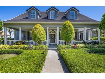 Charming home with a lush front yard and welcoming porch with columns at 9648 Weatherstone, Windermere, FL 34786