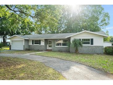Charming single-story home featuring a well-maintained front yard and a paved driveway at 9782 County Road 121, Wildwood, FL 34785