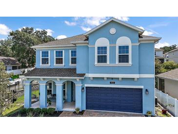 Charming two-story home with a covered front porch and a brick paver driveway leading to the garage at 1155 Dora Parc Ln, Mount Dora, FL 32757