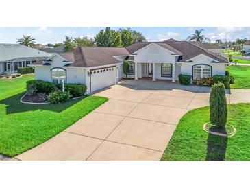 Beautiful home showcasing a large driveway, attached garage, and well-manicured lawn at 12118 Se 175Th Loop, Summerfield, FL 34491