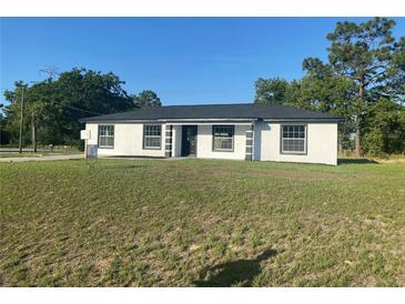 Charming single-story home with a well-manicured lawn, contrasting trim, and a classic design at 2 Pine Terrace Way, Ocala, FL 34472