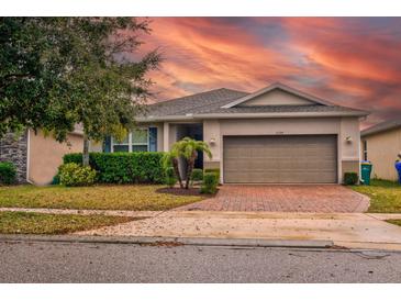 Charming single-Gathering home with a brick driveway, landscaping, and beautiful sunset sky at 3194 Bayou Ln, Tavares, FL 32778