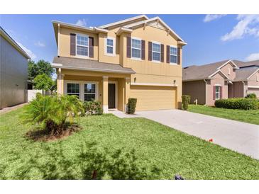 Two-story home featuring a manicured front yard and a spacious driveway leading to an attached two-car garage at 422 Rock Springs Cir, Groveland, FL 34736
