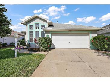 Charming single-story home featuring a two-car garage, beautiful landscaping, and a welcoming facade at 5604 Gulf Stream St, Tavares, FL 32778