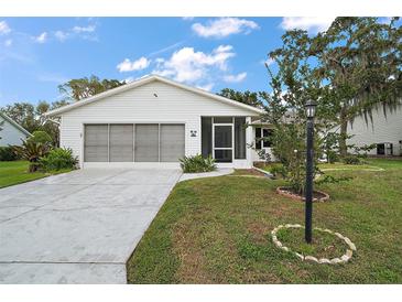 Charming single-story home featuring a two-car garage, screened front porch, and well-maintained landscaping at 5618 Rosewall Cir, Leesburg, FL 34748
