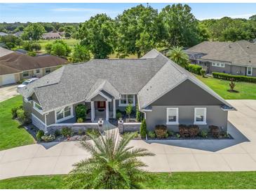 Stunning single-story home featuring a well-manicured lawn and a neutral color scheme exterior at 563 Dowling Cir, Lady Lake, FL 32159