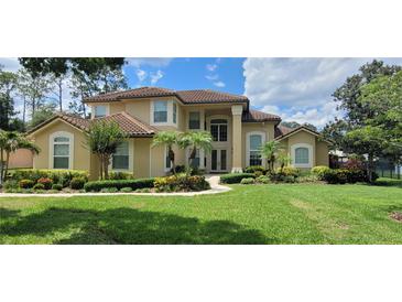 Stunning two-story home with a well-manicured lawn, lush landscaping, and beautiful curb appeal at 8719 Kenmure Cv, Orlando, FL 32836