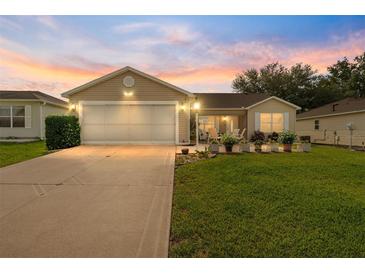Charming single-story home with a well-manicured lawn and an attached two-car garage at 965 Eastmont Ct, The Villages, FL 32162