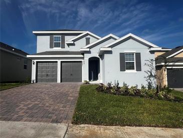 Charming two-story home with a brick driveway and well-maintained landscaping at 1881 Sunshine Peak Dr, Minneola, FL 34715
