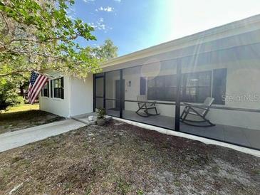 Welcoming screened-in porch with rocking chairs for relaxing and enjoying the outdoors at 2227 S Spring Garden Ave, Deland, FL 32720