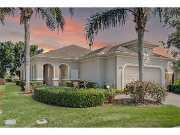 Charming single-Gathering home featuring a two-car garage, manicured lawn and lush landscaping at 2602 Stargrass Cir, Clermont, FL 34715