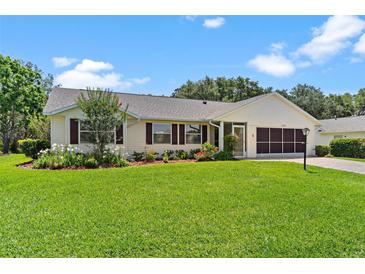 Charming single-story home boasts lush landscaping, a screened garage, and a beautifully maintained lawn at 26608 Racquet Cir, Leesburg, FL 34748
