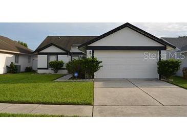 Charming single-story home featuring a well-manicured lawn and attached two-car garage at 3041 Bloomsbury Dr, Kissimmee, FL 34747