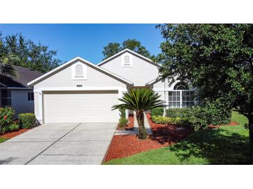 Charming home featuring a well-manicured lawn, mature trees, and a two-car garage at 3706 Doune Way, Clermont, FL 34711