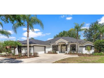 Charming single-story home featuring manicured landscaping, fresh exterior paint and a two-car garage at 39634 Harbor Hills Blvd, Lady Lake, FL 32159