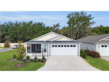 Charming single-story home boasts a well-manicured lawn, screened porch, and a two-car garage at 3984 Kanawha Pl, The Villages, FL 32163