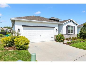 Charming single-story home with a two-car garage and well-manicured landscaping at 8178 Penrose Pl, Wildwood, FL 34785