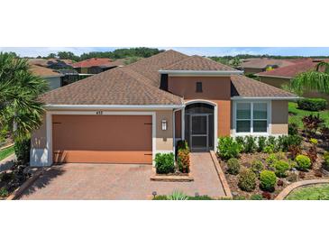 Charming single-story home showcasing a well-manicured lawn and beautiful landscaping at 453 Treviso Dr, Poinciana, FL 34759
