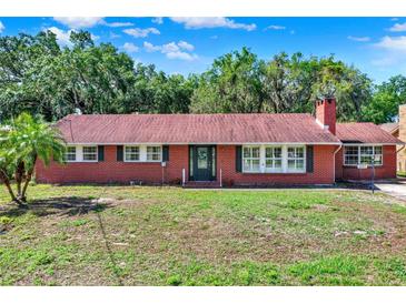 Charming brick home featuring a classic design and lush landscaping at 1007 N Shore Dr, Leesburg, FL 34748