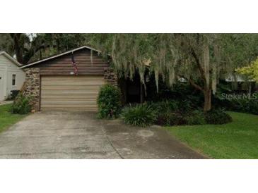Charming exterior featuring a wood facade, stone accents, and an attached two-car garage at 111 Frosti Way, Eustis, FL 32726
