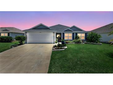 Charming single-story home with a well-manicured lawn and an attached two-car garage at 11287 Stewart Loop, Oxford, FL 34484