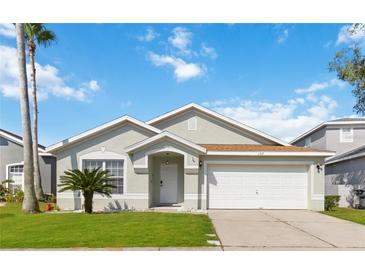 Charming single-story home featuring a well-manicured lawn, a two-car garage, and a welcoming front entrance at 157 Julliard Blvd, Davenport, FL 33897