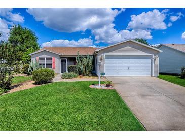 Charming single-story home with well-maintained lawn and a two-car garage at 17009 Se 96Th Chapelwood Cir, The Villages, FL 32162