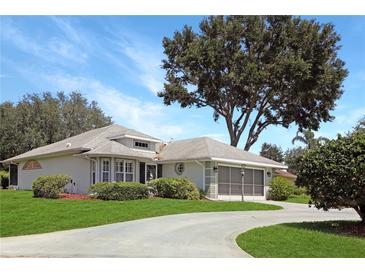 Charming single-story home featuring well-manicured landscaping and a spacious driveway, highlighting curb appeal at 21926 King Alfred St, Leesburg, FL 34748