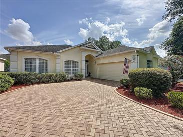 Charming home featuring a brick driveway, manicured landscaping, and a welcoming entrance at 2415 Twickingham Ct, Clermont, FL 34711