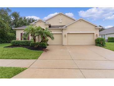 Charming home with a two-car garage, lush landscaping, and well-maintained lawn at 2424 Plumadore Dr, Grand Island, FL 32735