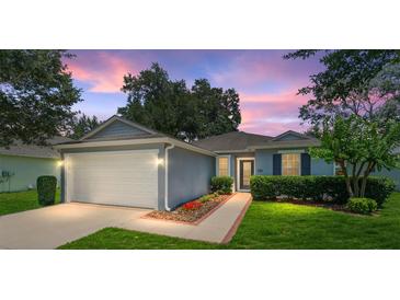 Charming single-story home featuring lush landscaping, well-manicured lawn and a two-car garage at 26822 Bull Run, Leesburg, FL 34748