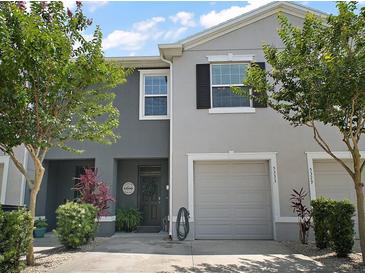 Inviting two-story townhome featuring a one-car garage and a charming front door with a 'Welcome' sign at 5333 Loblolly Ln, Wildwood, FL 34785