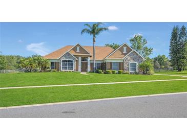 Charming single Gathering home with stone accents and lush landscaping at 7629 Lake Angelina Dr, Mount Dora, FL 32757