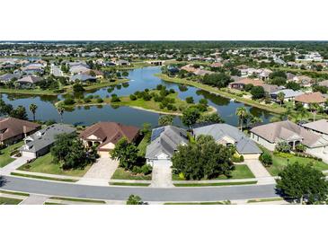 Scenic aerial view of homes surrounding a peaceful lake in a well-manicured community at 7873 Crosswinds Way, Mount Dora, FL 32757