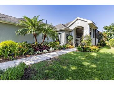 Charming home featuring a well-manicured lawn, lush landscaping, and a welcoming walkway at 7873 Crosswinds Way, Mount Dora, FL 32757