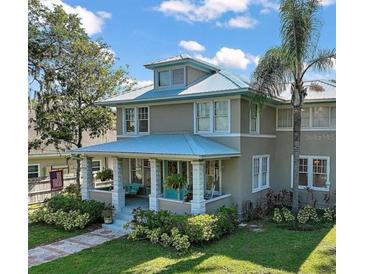 Charming two-story home featuring a welcoming front porch and beautifully landscaped front yard with a metal roof at 101 S Dixie Ave, Fruitland Park, FL 34731