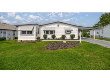 Charming single-story home with a well-manicured lawn and tidy landscaping at 1146 W Boone Ct, Lady Lake, FL 32159
