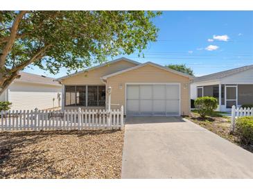 Charming single-story home with a well-maintained lawn, inviting front entrance, and attached garage at 1615 Navidad St, The Villages, FL 32162