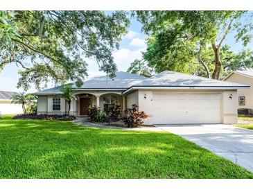 Charming single-story home featuring a well-manicured lawn, mature trees, and an attached two-car garage at 2711 Bayview Dr, Eustis, FL 32726