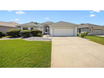 Charming single-story home featuring a well-manicured lawn, paved driveway, and a two-car garage at 3008 Bridgefield Ct, The Villages, FL 32162