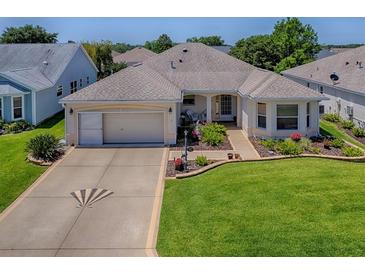 Charming single-story home with a well-manicured lawn and a two-car garage at 3112 Burbank Ln, The Villages, FL 32162