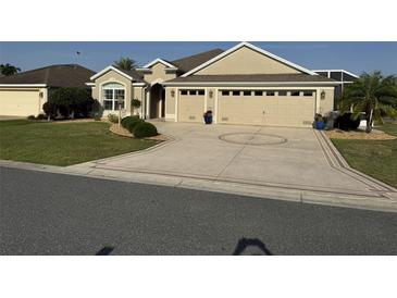 Charming single-story home featuring a well-manicured lawn and a decorative driveway leading to a spacious two-car garage at 3411 Eisenhower Way, The Villages, FL 32163