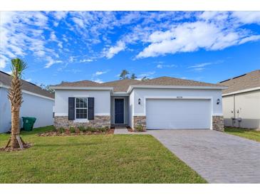 Charming single-story home featuring a two-car garage, stone accents, and a well-manicured lawn at 5013 Balsam Falls Rd, Deland, FL 32724