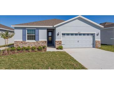 Charming one-story home with stone accents, light blue exterior and well-maintained landscaping at 5017 Balsam Falls Rd, Deland, FL 32724