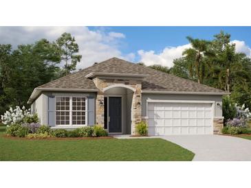 Charming single-story home with stone accents, a two-car garage, and lush landscaping at 5036 Balsam Falls Rd, Deland, FL 32724