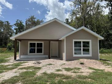 Charming single-story home featuring a covered porch and neutral-toned siding, new construction at 919 Cr 482C, Lake Panasoffkee, FL 33538