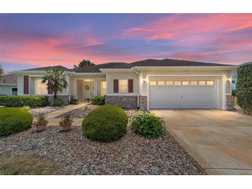 Charming single-story home features a well-manicured lawn, lovely landscaping, and a two-car garage at 13165 Se 93Rd Cir, Summerfield, FL 34491