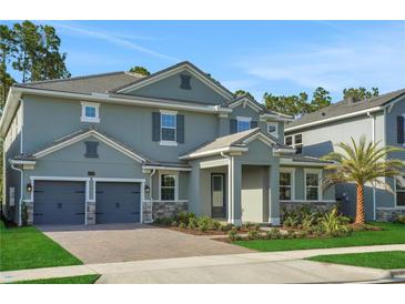 Charming two-story home featuring a brick driveway, two car garage, and beautifully landscaped front yard at 14261 Crest Palm Ave, Windermere, FL 34786