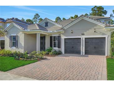 Beautiful single-story home featuring a brick driveway and a two-car garage at 14285 Crest Palm Ave, Windermere, FL 34786