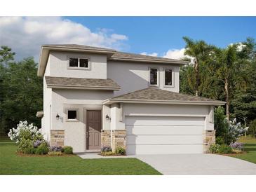 Charming two-story home with a neutral color scheme, stone accents and an attached two-car garage at 2004 Sunshine Peak Dr, Minneola, FL 34715